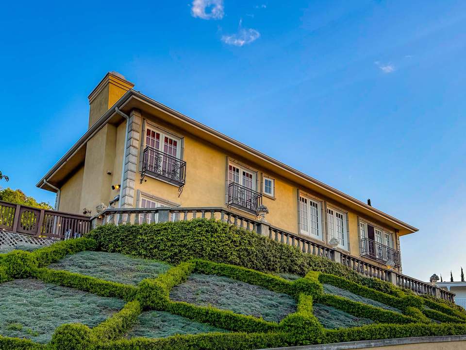 Vista Villa's Spanish-style front: cream stucco, wrought-iron Juliet balconies and a sculpted geometric lawn