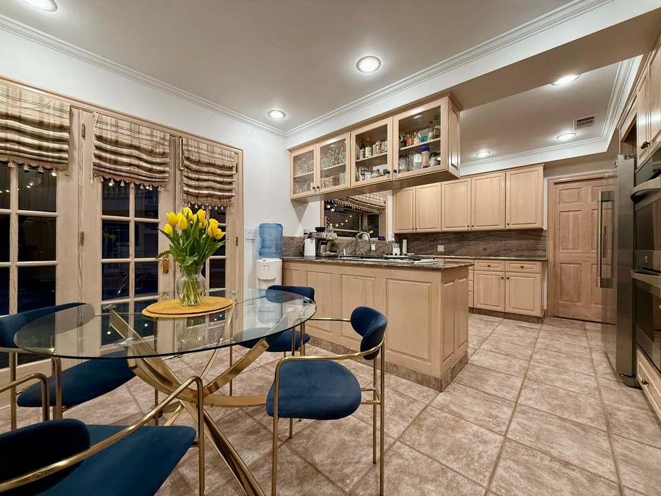 Kitchen with a glass breakfast table, central island and double wall ovens