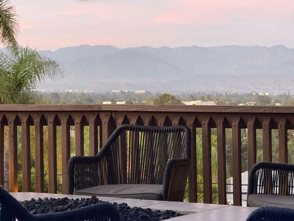 Chairs around the gas fire table facing the mountains at sunset