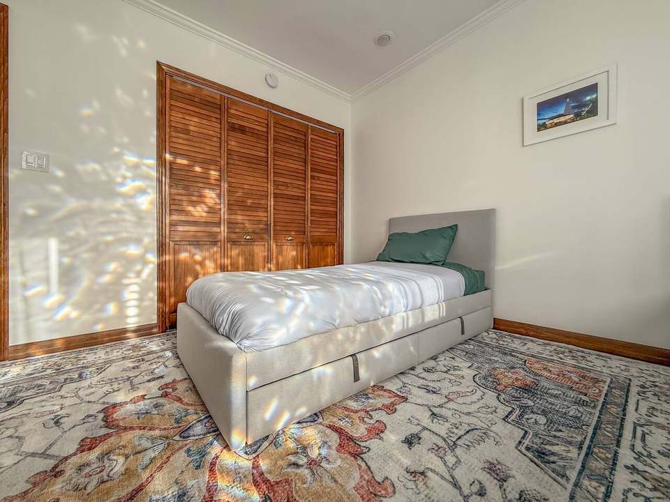 Twin bedroom with a stained-glass window pattern of light across the bed