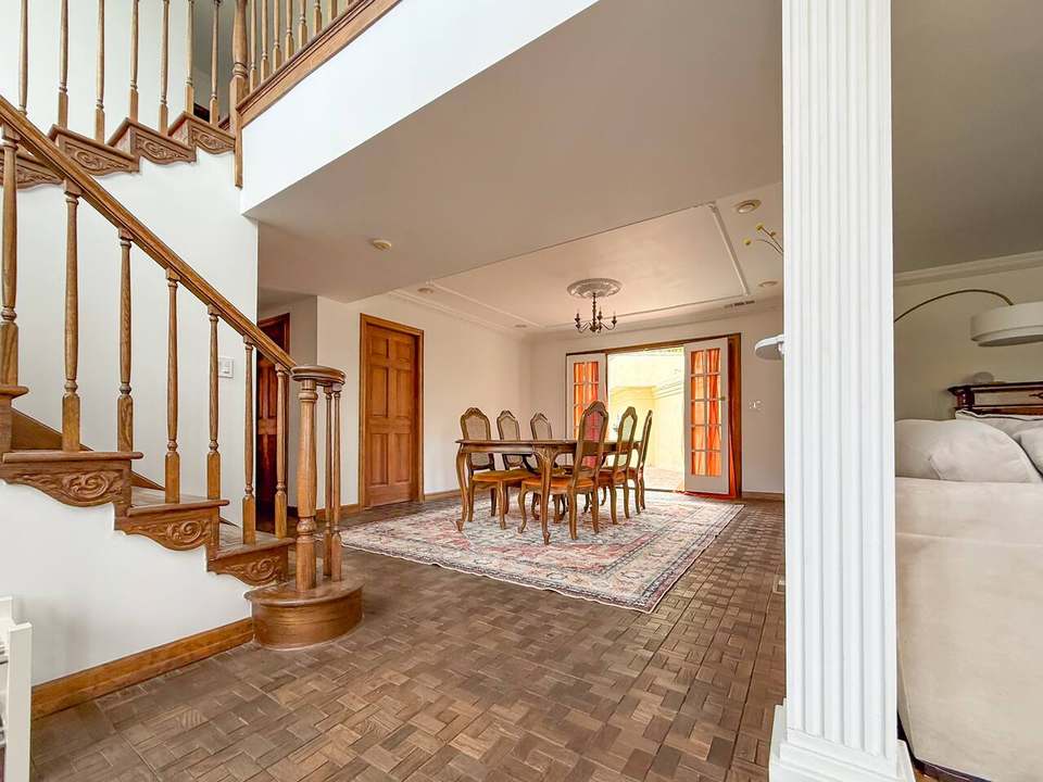 View across the entry staircase to the dining table and open French doors