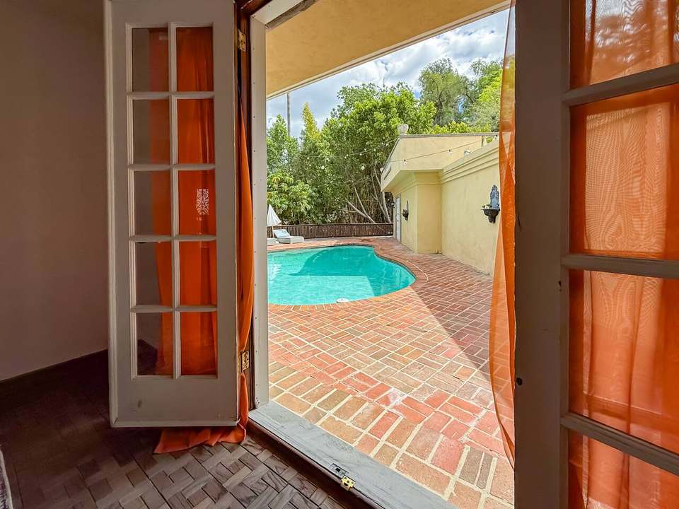 French doors opening from the dining room onto the brick pool deck