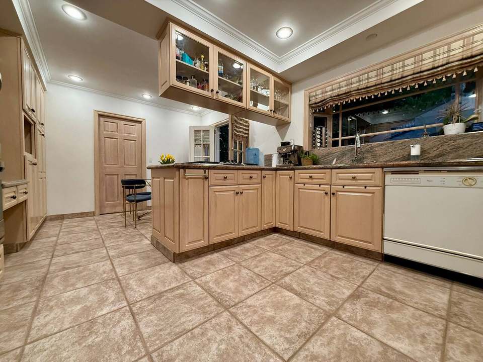 Kitchen with granite counters, oak cabinets and a central prep island