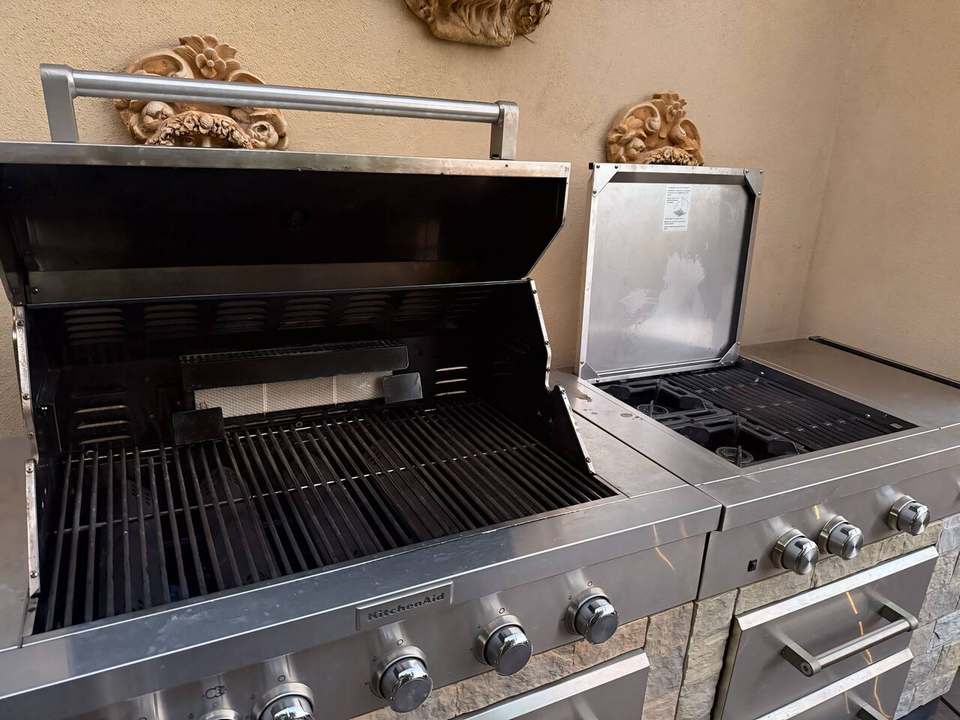 Stainless natural-gas grill open, with side burners and a warming drawer