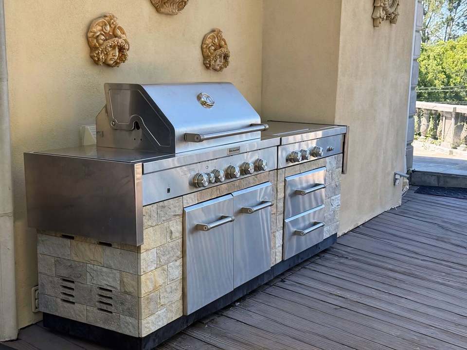 Outdoor kitchen with a stainless natural-gas grill set in stone